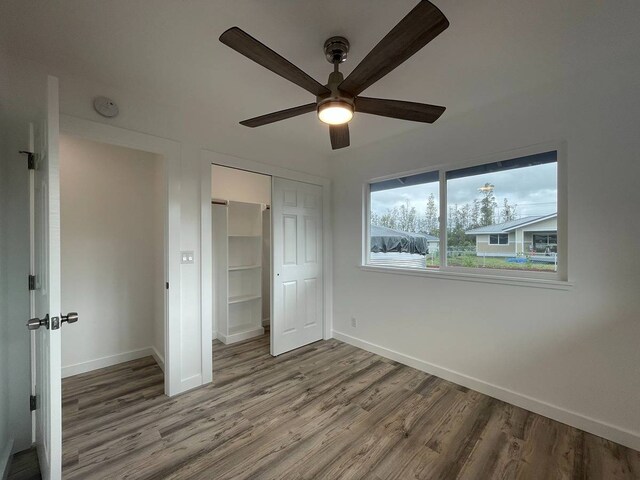 unfurnished bedroom with ceiling fan, hardwood / wood-style flooring, and a closet