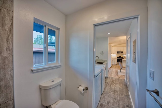 bathroom with toilet, vanity, and wood-type flooring