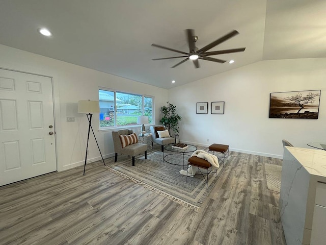 living room with lofted ceiling, ceiling fan, and light wood-type flooring