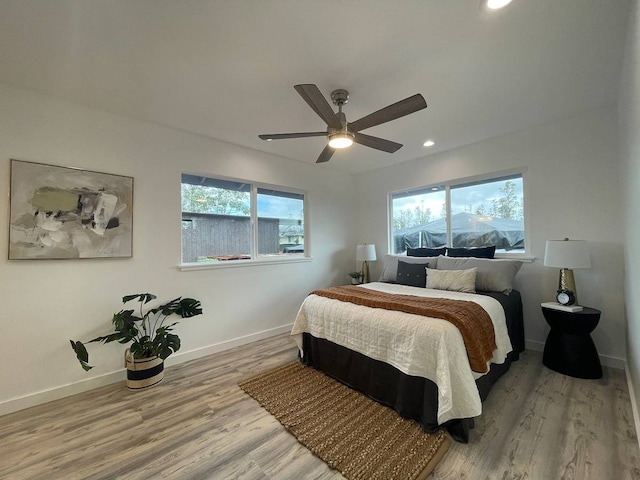 bedroom with light hardwood / wood-style floors and ceiling fan