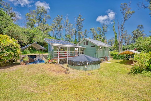 rear view of house featuring a swimming pool and a lawn