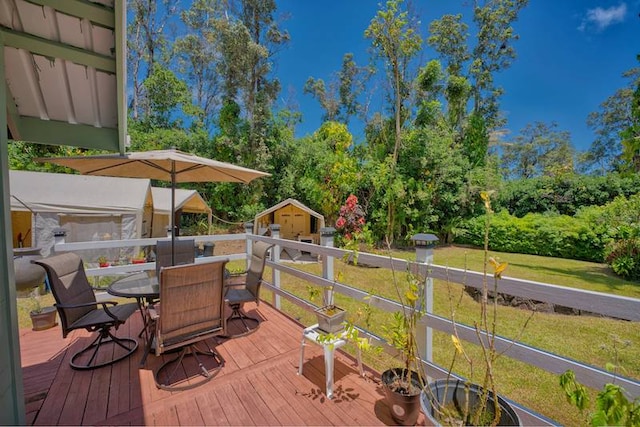 deck with a lawn and a storage shed