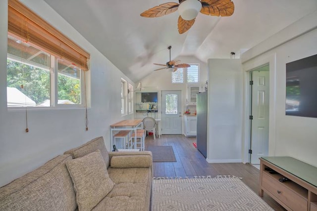 living room featuring lofted ceiling, dark hardwood / wood-style floors, ceiling fan, and a healthy amount of sunlight