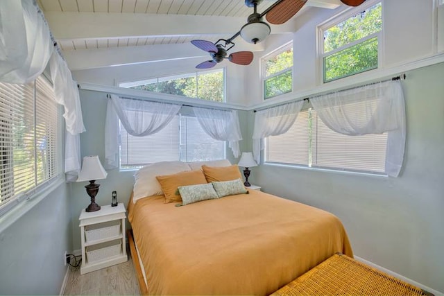 bedroom featuring ceiling fan, multiple windows, light wood-type flooring, and vaulted ceiling