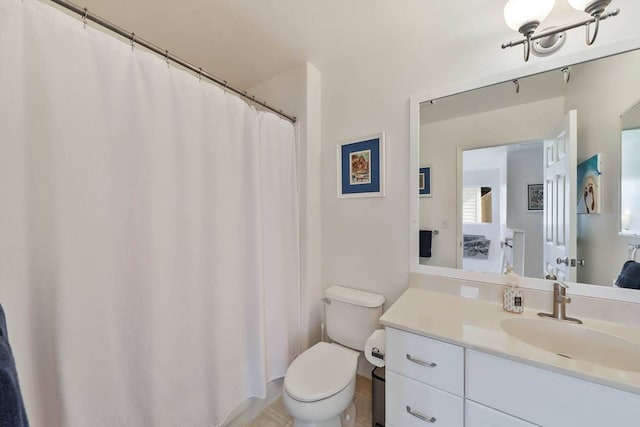 bathroom with tile flooring, toilet, and vanity