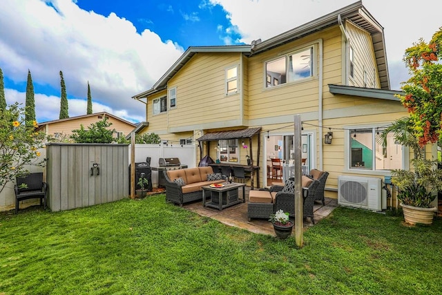 rear view of property with outdoor lounge area, a yard, a patio area, and a storage shed