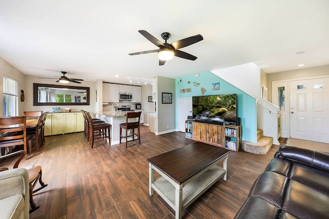 living room with dark hardwood / wood-style floors, ceiling fan, and sink