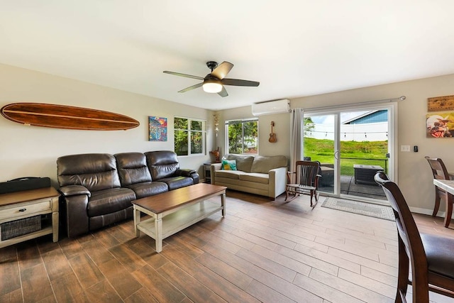 living room with a wall mounted AC, ceiling fan, and dark wood-type flooring