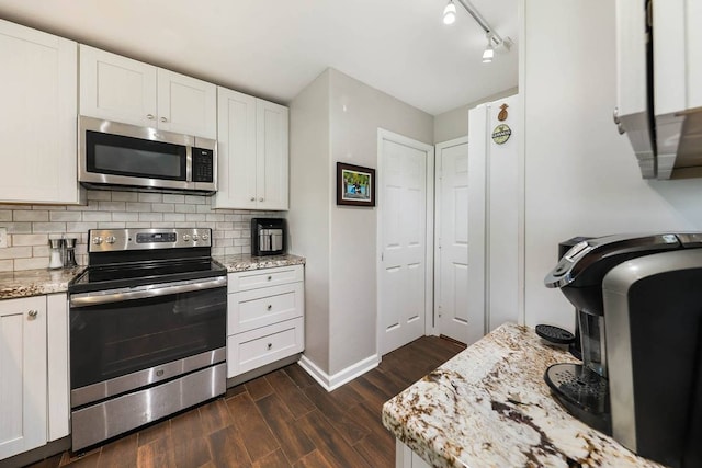 kitchen with white cabinets, stainless steel appliances, and dark hardwood / wood-style flooring