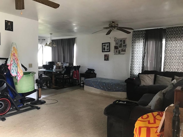 living room featuring carpet flooring and ceiling fan with notable chandelier