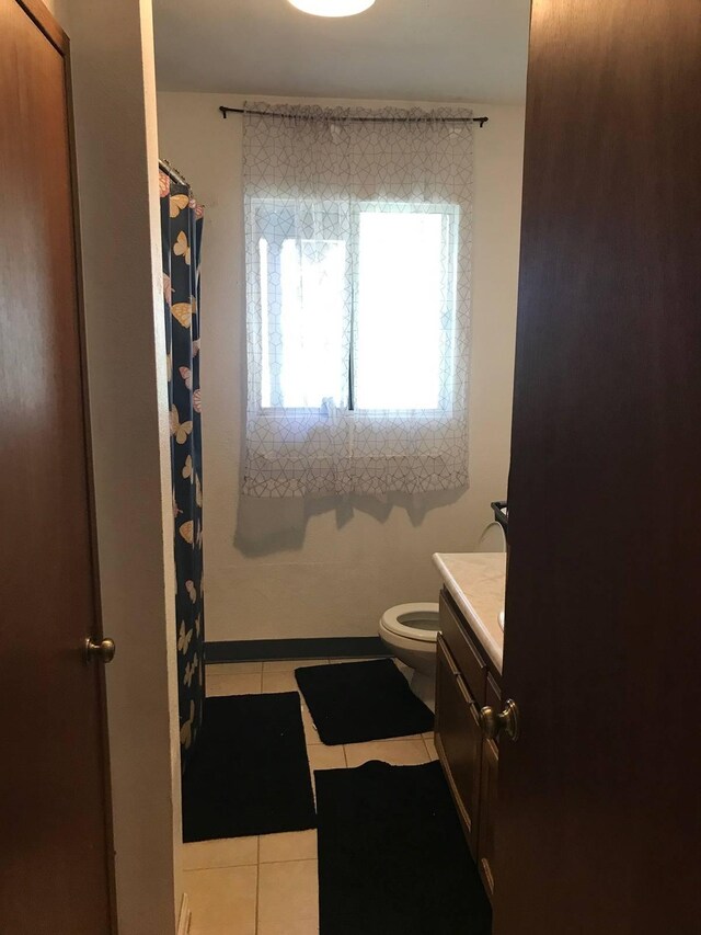 bathroom featuring toilet, tile floors, and vanity