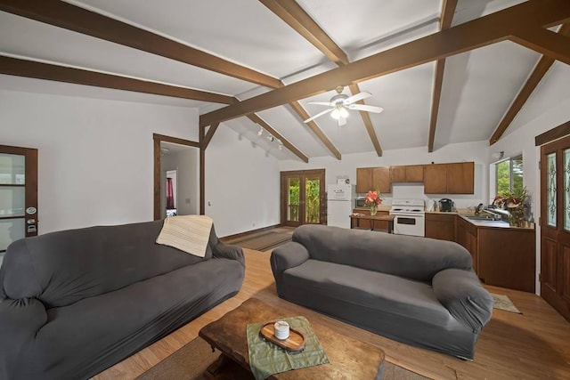 living room featuring lofted ceiling with beams, ceiling fan, sink, and light hardwood / wood-style flooring