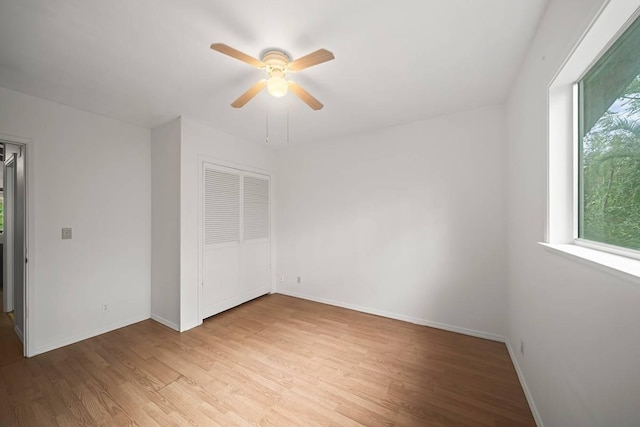 unfurnished bedroom with ceiling fan, light hardwood / wood-style flooring, and a closet