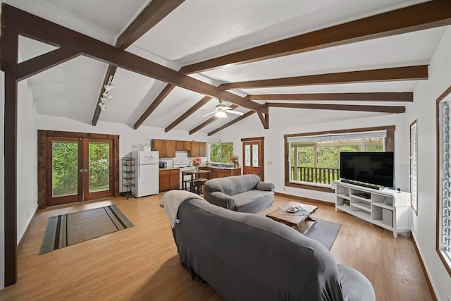 living room with vaulted ceiling with beams, a wealth of natural light, light hardwood / wood-style flooring, and french doors