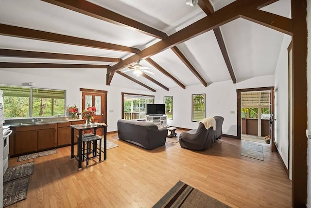 living room featuring a wealth of natural light, lofted ceiling with beams, light hardwood / wood-style floors, and ceiling fan