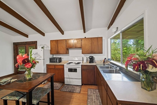 kitchen with beam ceiling, white appliances, light hardwood / wood-style flooring, and sink