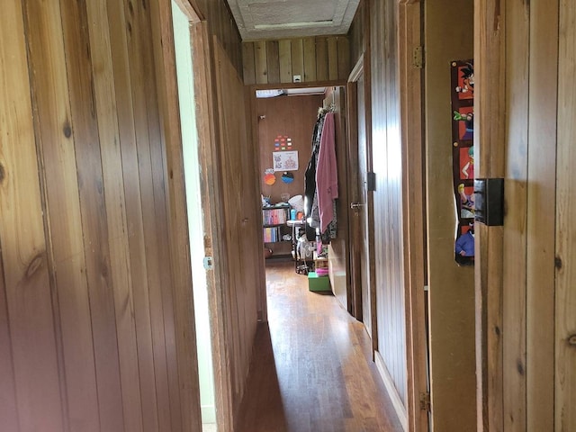 hallway featuring wood walls and wood-type flooring