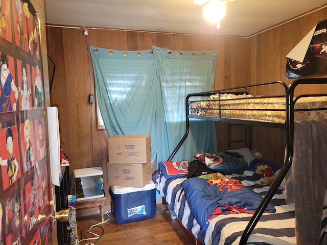 bedroom with wood walls and hardwood / wood-style floors