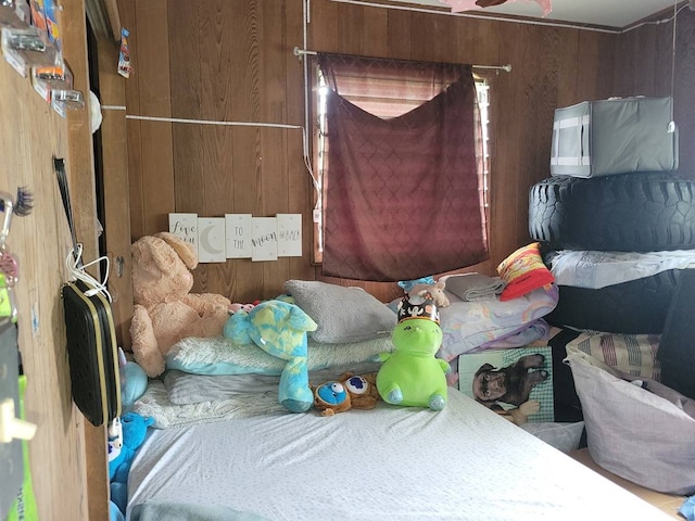 bedroom featuring wooden walls