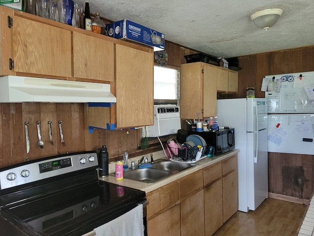 kitchen with a textured ceiling, stainless steel electric range oven, wood-type flooring, and sink