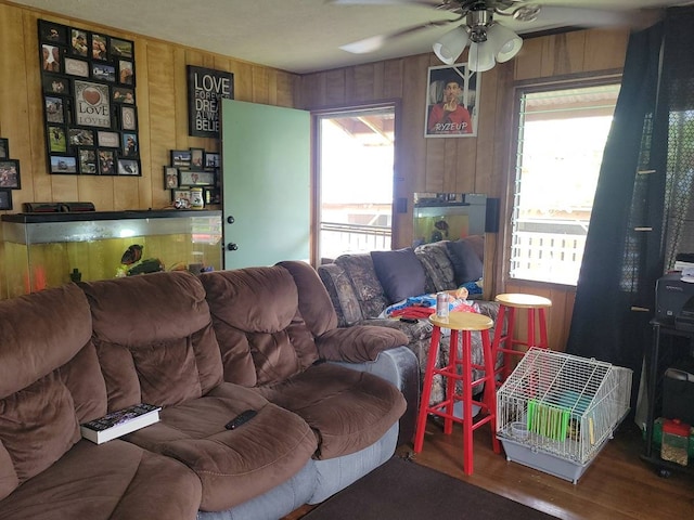 living room featuring wooden walls, ceiling fan, and dark hardwood / wood-style flooring