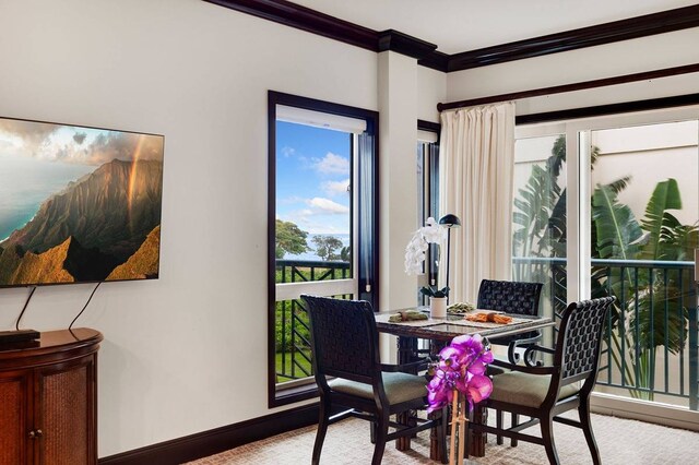 carpeted dining area featuring crown molding