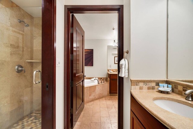 bathroom featuring separate shower and tub, tile flooring, and vanity