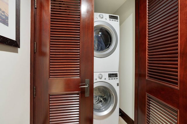 clothes washing area with stacked washing maching and dryer