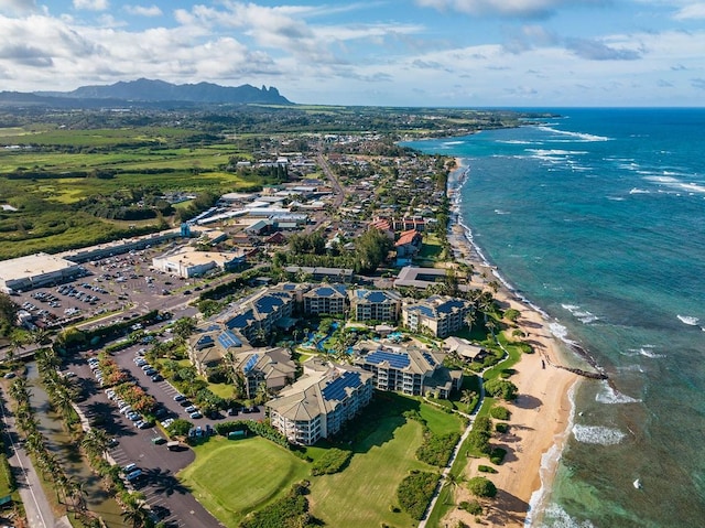 drone / aerial view with a water and mountain view and a view of the beach