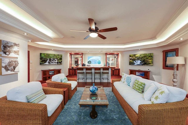 living room with ceiling fan, crown molding, a tray ceiling, and dark hardwood / wood-style flooring