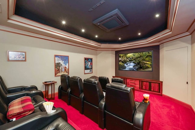 home theater room featuring ornamental molding, a raised ceiling, and carpet flooring