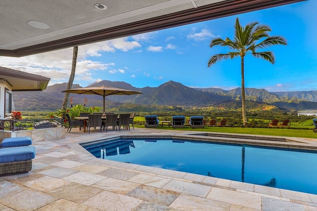 view of swimming pool featuring a mountain view and a patio