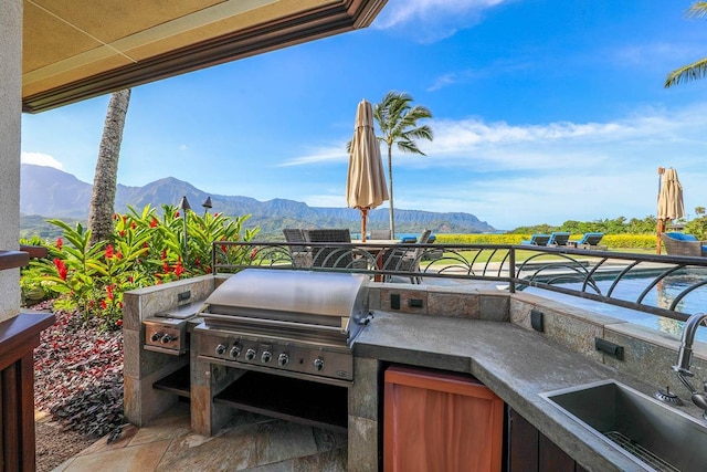 view of patio featuring a mountain view, area for grilling, sink, and exterior kitchen