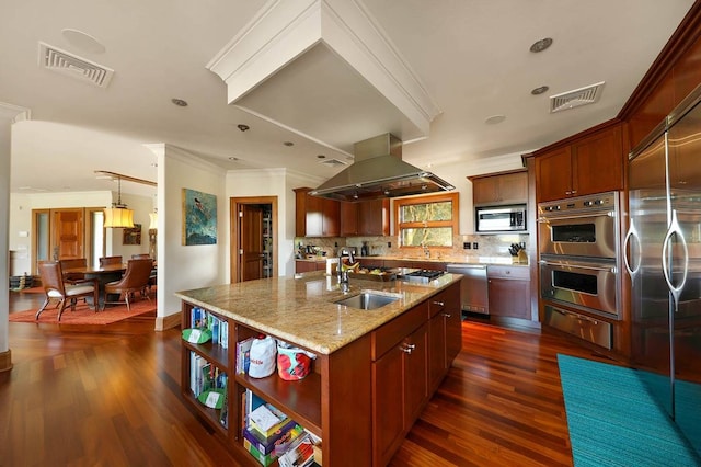 kitchen featuring island exhaust hood, backsplash, stainless steel appliances, dark wood-type flooring, and light stone countertops