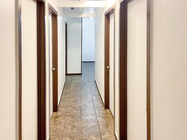 hallway with dark tile floors