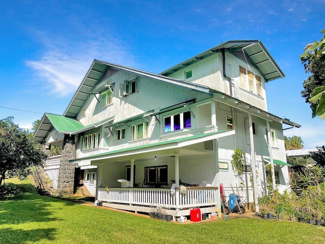 rear view of property featuring a yard and covered porch