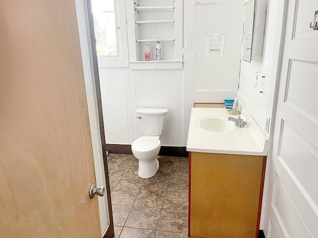 bathroom featuring tile floors, vanity with extensive cabinet space, and toilet