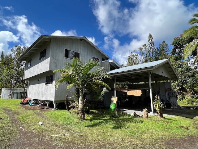 view of side of home featuring an outbuilding and a lawn