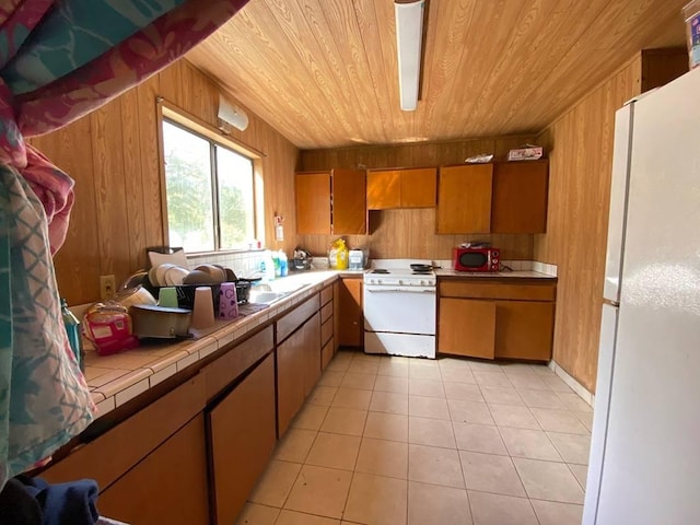 kitchen featuring light tile patterned floors, wood ceiling, tile countertops, wood walls, and white appliances