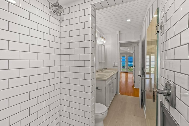 bathroom with tiled shower and vanity