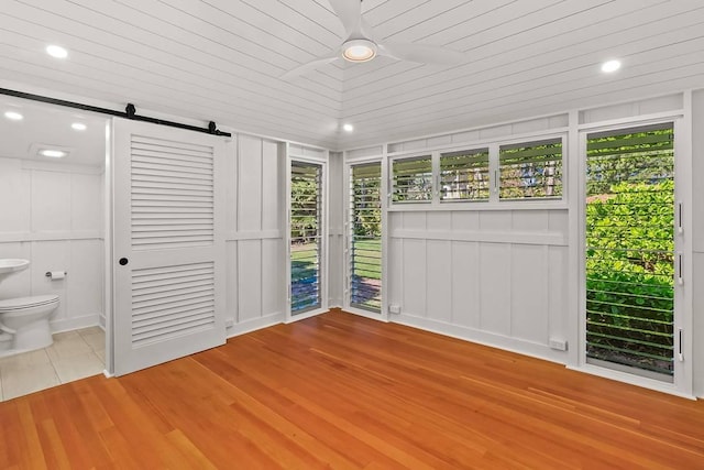 unfurnished sunroom with a barn door and wooden ceiling