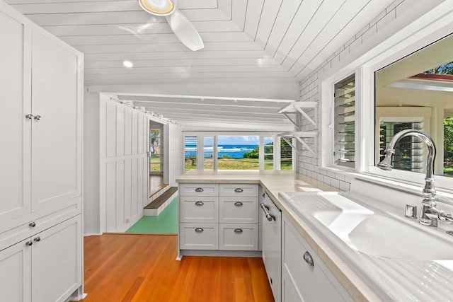 bathroom with hardwood / wood-style flooring, plenty of natural light, wooden ceiling, and sink