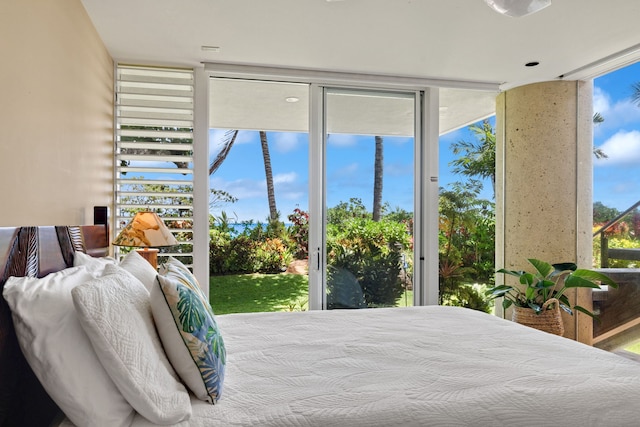 bedroom featuring access to outside and a wall of windows