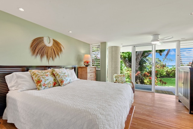 bedroom featuring ceiling fan, multiple windows, and light wood-type flooring