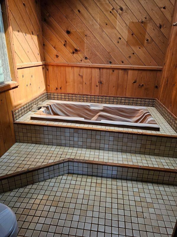 bathroom with tile patterned floors and a tub