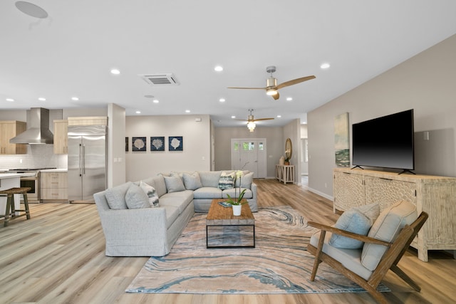 living room with ceiling fan and light hardwood / wood-style flooring