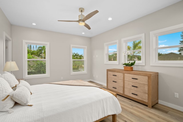 bedroom featuring multiple windows, light wood-type flooring, and ceiling fan