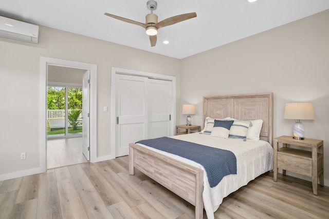 bedroom featuring access to exterior, a wall unit AC, ceiling fan, light hardwood / wood-style floors, and a closet