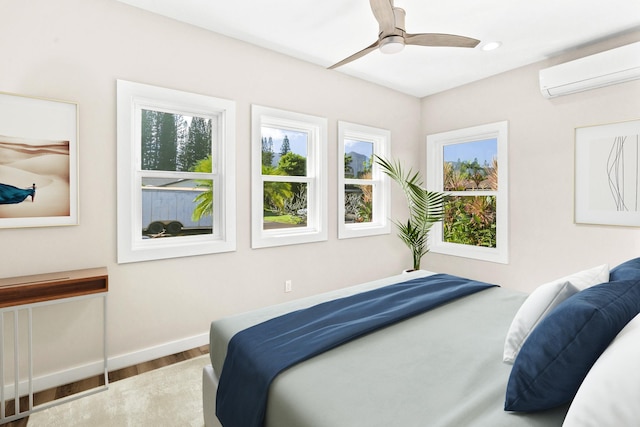 bedroom with hardwood / wood-style floors, ceiling fan, and a wall unit AC