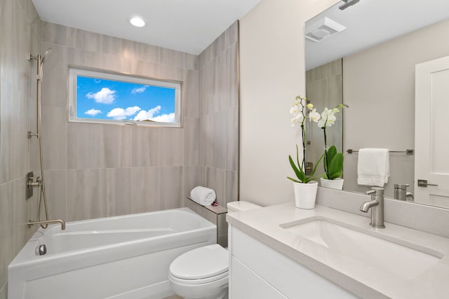 full bathroom with vanity, toilet, and tiled shower / bath combo